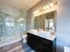 Spacious bathroom featuring dual sinks, modern lighting, and glass-enclosed shower at 8125 Rio De Janeiro Dr, Las Vegas, NV 89128