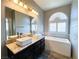 Bathroom featuring double sinks, a soaking tub, and granite countertops at 8125 Rio De Janeiro Dr, Las Vegas, NV 89128