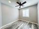 Bedroom featuring gray walls, a ceiling fan, shutters, and gray wood-look flooring at 8125 Rio De Janeiro Dr, Las Vegas, NV 89128