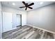 Bedroom with gray walls, ceiling fan, wood-look floors, closet, and white doors at 8125 Rio De Janeiro Dr, Las Vegas, NV 89128