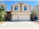 Inviting two-story home with arched windows, a spacious driveway, and a two-car garage, perfect for a Gathering at 8125 Rio De Janeiro Dr, Las Vegas, NV 89128