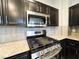Close-up of stainless steel gas range with granite countertops and dark cabinets at 8125 Rio De Janeiro Dr, Las Vegas, NV 89128