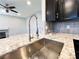 Kitchen island with stainless steel sink and granite countertops, view to fireplace at 8125 Rio De Janeiro Dr, Las Vegas, NV 89128