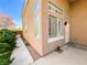 Home's side exterior featuring ample windows, manicured landscaping, and a secure gate, combining privacy with aesthetic appeal at 8125 Rio De Janeiro Dr, Las Vegas, NV 89128
