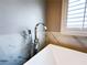 Elegant faucet and hand shower attachment beside the modern soaking tub at 8125 Rio De Janeiro Dr, Las Vegas, NV 89128
