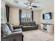 Comfortable living room with dual sofas, ceiling fan, and a sleek entertainment center at 8490 Classique Ave # 101, Las Vegas, NV 89178