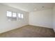 Bedroom featuring large windows, carpeted floor, and neutral wall paint at 89 Via Franello, Henderson, NV 89011