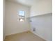 Bright laundry room with tile flooring, a window and a shelf for storage at 89 Via Franello, Henderson, NV 89011
