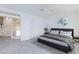 Main bedroom view featuring vaulted ceiling, ceiling fan, adjoining sitting area, and a modern platform bed at 92 Sea Holly Way, Henderson, NV 89074