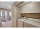 Functional laundry area equipped with washer, dryer, and white overhead cabinets at 9303 Gilcrease Ave # 2217, Las Vegas, NV 89149