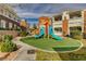 Community playground with colorful slides and lush landscaping at 9303 Gilcrease Ave # 2217, Las Vegas, NV 89149