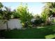 A beautiful backyard showcases lush green artificial grass, manicured landscaping and a white block fence at 9440 Grenville Ave, Las Vegas, NV 89134