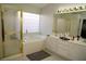 Bright bathroom with a glass-enclosed shower, soaking tub, and dual sink vanity at 9440 Grenville Ave, Las Vegas, NV 89134