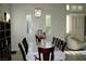 Bright dining room with large windows, a chandelier, and a dark wood table that seats eight guests at 9440 Grenville Ave, Las Vegas, NV 89134