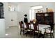 Open dining room featuring white tile flooring, a chandelier, and a dark wood table with eight chairs at 9440 Grenville Ave, Las Vegas, NV 89134