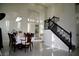 Elegant dining room featuring a grand staircase, large windows with shutters, and a chandelier for a luxurious feel at 9440 Grenville Ave, Las Vegas, NV 89134