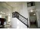 Bright foyer featuring a staircase with wrought iron railing and a seating area with three chairs at 9440 Grenville Ave, Las Vegas, NV 89134