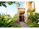 Charming home entrance with an ornate door, green landscaping, and a paved walkway at 9440 Grenville Ave, Las Vegas, NV 89134