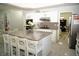 Bright kitchen features white cabinets, granite countertops, stainless steel appliances, and a large kitchen island at 9440 Grenville Ave, Las Vegas, NV 89134