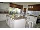 Bright kitchen features white cabinets, granite countertops, stainless steel appliances, and a large kitchen island at 9440 Grenville Ave, Las Vegas, NV 89134