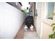 Narrow side yard featuring rock, a barbeque, a white block wall, and a secure gate at 9440 Grenville Ave, Las Vegas, NV 89134