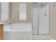 Bright bathroom featuring a soaking tub and separate shower with glass door at 9975 Sand Key St, Las Vegas, NV 89178