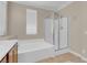 Bright bathroom featuring a soaking tub and separate shower with glass door at 9975 Sand Key St, Las Vegas, NV 89178