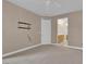 Bedroom with neutral carpet, ceiling fan, access to the ensuite bathroom, and blank wall at 9975 Sand Key St, Las Vegas, NV 89178