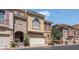 Charming townhome with a two car garage featuring an arched entry and manicured landscaping at 9975 Sand Key St, Las Vegas, NV 89178
