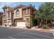 Charming townhome with a two-car garage and landscaped front, set on a sunny day at 9975 Sand Key St, Las Vegas, NV 89178