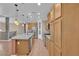 Modern kitchen boasts wood flooring, a center island, stainless steel appliances, and wooden cabinets at 9975 Sand Key St, Las Vegas, NV 89178