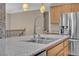 Close up of a well-lit kitchen featuring stainless steel appliances, granite countertops, and a chrome faucet at 9975 Sand Key St, Las Vegas, NV 89178