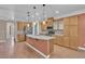 Bright kitchen features wood flooring, a center island, stainless steel appliances, wooden cabinets, and pendant lighting at 9975 Sand Key St, Las Vegas, NV 89178