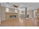 Open living room featuring a stone fireplace, a ceiling fan, and wood-look flooring at 9975 Sand Key St, Las Vegas, NV 89178