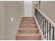 Elegant staircase with dark iron spindles and wood steps leading to the upper level at 9975 Sand Key St, Las Vegas, NV 89178