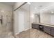 Modern bathroom featuring a glass shower, wood-look floors and a gray vanity at 10482 Calico Terrace Ave, Las Vegas, NV 89135