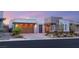 Modern home showcasing stone accents, a two-car garage, and well-manicured landscaping at sunset at 10482 Calico Terrace Ave, Las Vegas, NV 89135
