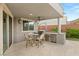 A convenient outdoor kitchen with a grill and counter space located under a covered patio with a ceiling fan at 10482 Calico Terrace Ave, Las Vegas, NV 89135