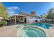 Inviting backyard with a sparkling pool, spa, covered patio, and lush green lawn, perfect for outdoor entertaining at 10518 Santerno St, Las Vegas, NV 89141