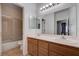 Bathroom featuring double sinks, a large mirror, and a glass shower at 10518 Santerno St, Las Vegas, NV 89141