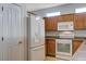 Kitchen with white appliances and wooden cabinetry at 10518 Santerno St, Las Vegas, NV 89141