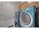 Laundry room featuring front loading washer and dryer with wall mounted cabinets at 10518 Santerno St, Las Vegas, NV 89141