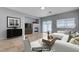 Staged living room with modern decor, fireplace, tile floors, and access to a patio via sliding glass door at 10518 Santerno St, Las Vegas, NV 89141