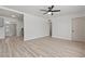 Open living room featuring sleek laminate floors, a modern ceiling fan, and fresh white paint at 1417 Dogwood Ave, North Las Vegas, NV 89030