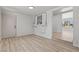 Neutral living room featuring wood-look floors, a small kitchen, and an exterior door at 1417 Dogwood Ave, North Las Vegas, NV 89030