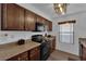Updated kitchen featuring granite countertops, dark cabinetry, and modern black appliances at 2451 N Rainbow Blvd # 2043, Las Vegas, NV 89108