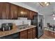 Traditional kitchen with wood cabinetry, granite countertops, stainless steel refrigerator, and a dining area at 2451 N Rainbow Blvd # 2043, Las Vegas, NV 89108