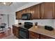 Kitchen featuring dark wood cabinets, granite countertops, black appliances, and wood-look flooring at 2451 N Rainbow Blvd # 2043, Las Vegas, NV 89108