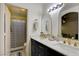 Modern bathroom featuring double sinks with gold hardware and a shower with neutral striped curtain at 3322 Dragon Fly St, North Las Vegas, NV 89032
