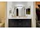 Modern bathroom features a double sink vanity, sleek black cabinets, gold hardware, and stylish arched mirrors at 3322 Dragon Fly St, North Las Vegas, NV 89032